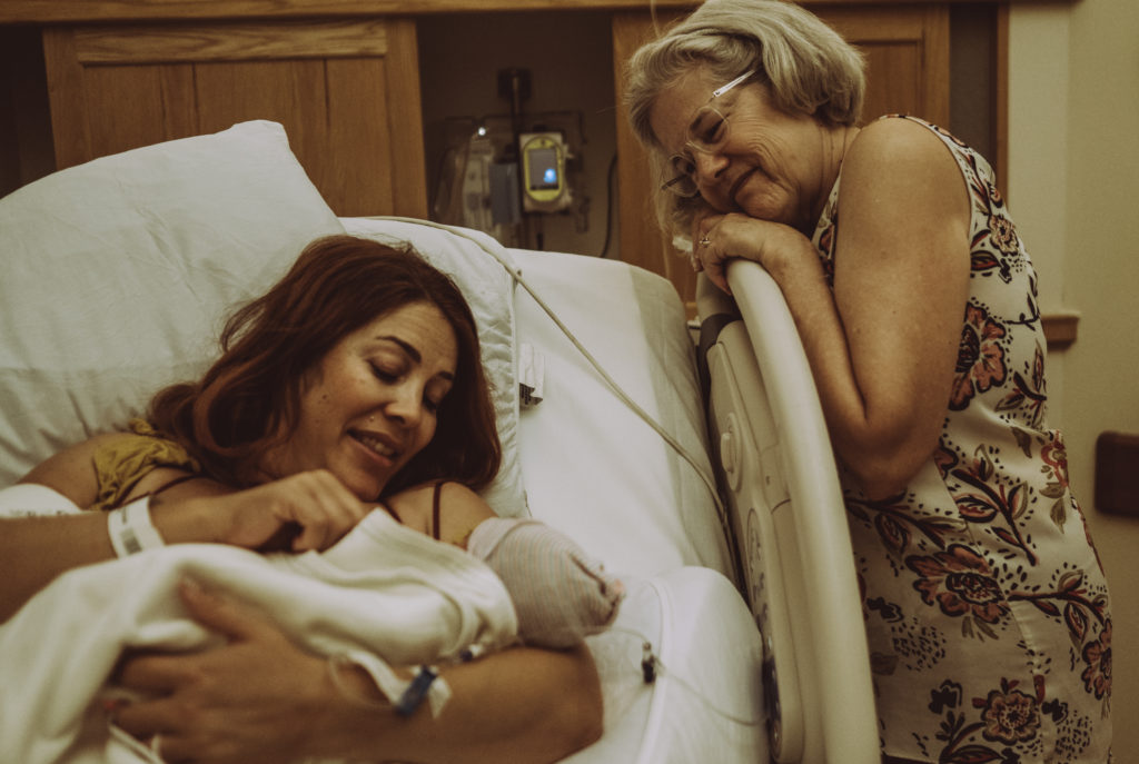 Grandmother gazing at daughter and new grandson in atlanta hospital 