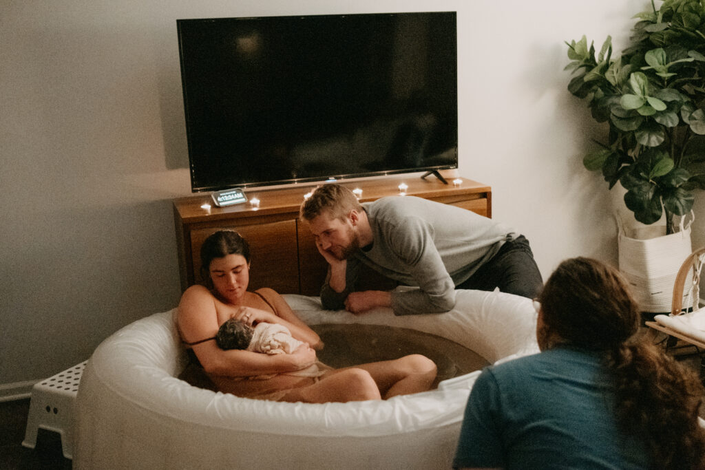 Kansas City Birth Photographer capturing the sweet bliss of dad gazing at new baby girl